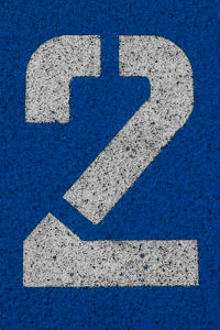 The number 2 in white stencil on a textured blue surface